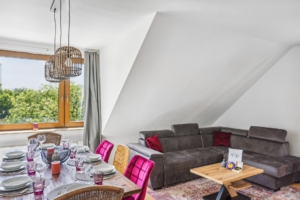 Gemütlicher Wohn- und Essbereich mit großer Fensterfront, großem Tisch für bis zu 8 Personen und Blick ins Grüne in der Monteurwohnung in Hameln