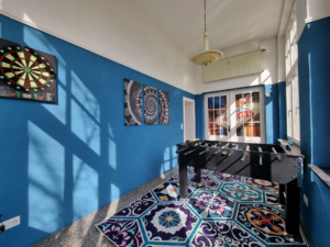 Unterhaltsames Spielzimmer mit Tischkicker und elektronischer Dartscheibe in der Ferienwohnung in Hameln ‘Jugendstil trifft Moderne’