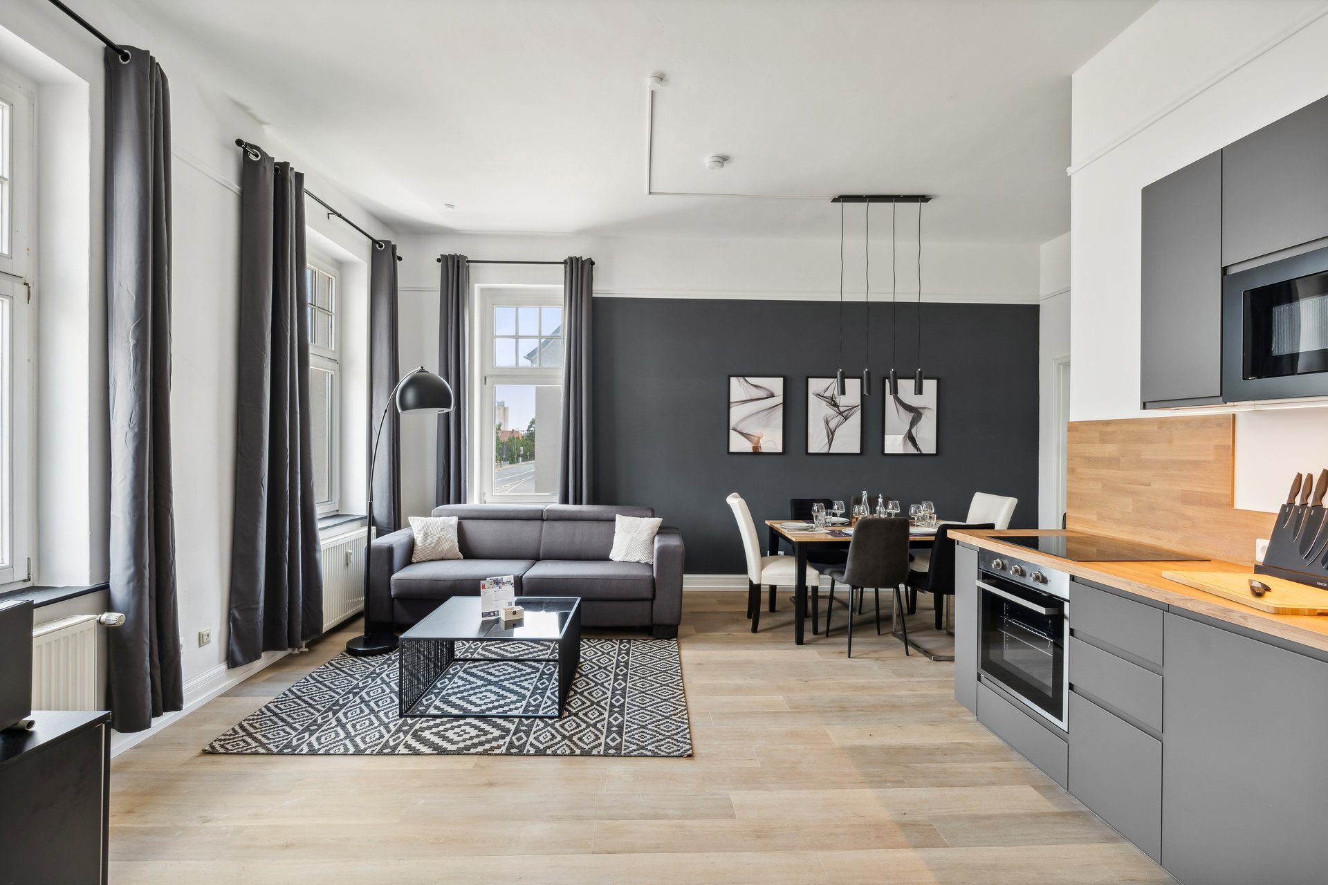 Ferienwohnung Hameln Juwel in Anthrazit – Wohnzimmer mit Essbereich, Schlafcouch, Smart-TV und integrierter Küchenzeile