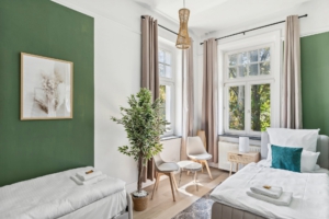Helles Schlafzimmer mit gemütlichen Betten und grünem Design in der Ferienwohnung Hameln